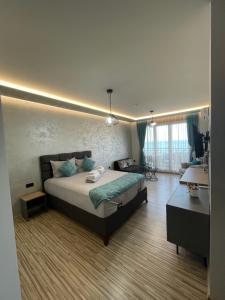 a bedroom with a bed and a desk in it at Апартаменти Генезис Ахтопол in Ahtopol