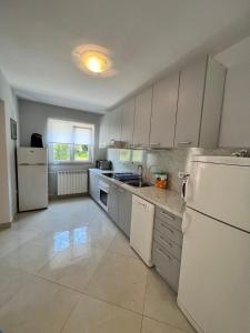 eine Küche mit weißen Geräten und einem weißen Kühlschrank in der Unterkunft Haus Zdenka in Rab