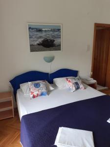 a bedroom with a blue bed with pillows on it at Guest House Vila Bak in Budva