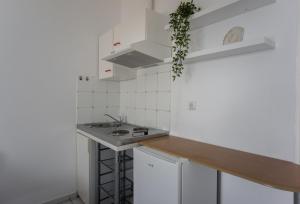 een keuken met witte kasten en een wastafel bij Fuga Rooms in Kanali