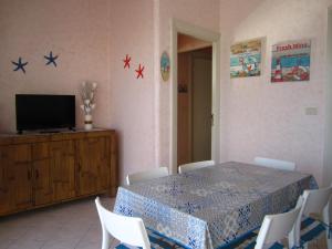 a dining room with a table and a television and stars on the wall at Alma Ùnica Fronte Mare in Lido di Ostia