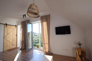 a living room with a large window and a tv at Johnny House 2 in Suwałki