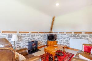 a living room with a couch and a wood stove at Robin's Nest in Craven Arms