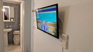 einen Flachbild-TV an einer Wand im Bad in der Unterkunft BeachHouse in Arkondikó