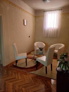 a living room with chairs and a table and a window at Szent István Wellness Panzió in Makó