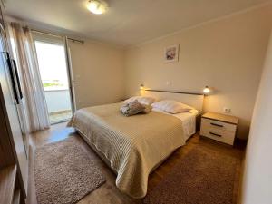 a small bedroom with a bed and a window at Haus Zdenka in Rab