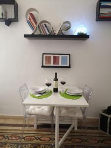 Biały stół z dwoma kieliszkami i butelką wina w obiekcie La luminaria w mieście Bari