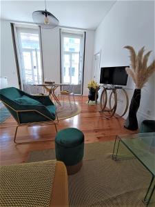 a living room with a couch and chairs and a tv at Appartement Pont Luiz in Porto