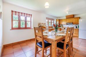 a kitchen and dining room with a wooden table and chairs at Byne Brook Cottage in Wistanstow