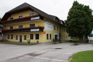 a yellow building with a tree in front of it at Landgasthof Kammerhof in Aigelsbach