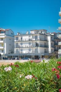 a large white building with flowers in front of it at Hotel Riviera in Caorle