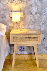 a table with a lamp on it next to a bed at Labreña Hotel in Los Caños de Meca