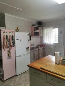 uma cozinha com um frigorífico branco e um balcão em VESA Guesthouse em Meyerton