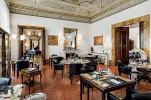 フィレンツェにあるPalazzo Firenze by Baglioni Hotels & Resortsの天井のレストラン(テーブル、椅子付)