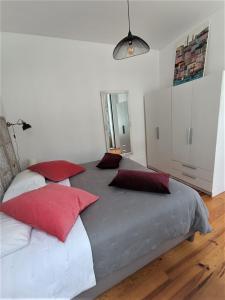 ポルトにあるAppartement Pont Luizの大型ベッド(赤と白の枕付)