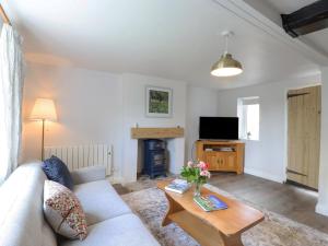 a living room with a couch and a coffee table at Bluebird Cottage in Higham