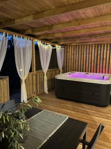 uma banheira de hidromassagem num deque de madeira com cortinas em Rosmarin&Olive Premium Mobile Homes em Selce
