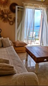 ein Wohnzimmer mit Tisch und Blick auf das Meer in der Unterkunft BeachHouse in Arkondikó