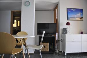 a living room with a table and chairs and a tv at Al despertar ver el mar in Benidorm