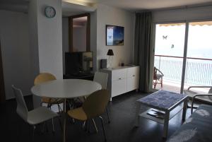 a living room with a table and chairs and a television at Al despertar ver el mar in Benidorm