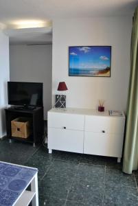 a living room with a white dresser and a television at Al despertar ver el mar in Benidorm