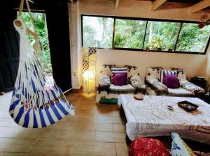 Zimmer mit 2 Betten und einer Hängematte. in der Unterkunft Casajungla Hostel in Jacó