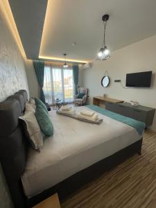 a bedroom with a large bed with a television on it at Апартаменти Генезис Ахтопол in Ahtopol