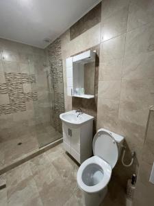 a bathroom with a toilet and a sink and a shower at Апартаменти Генезис Ахтопол in Ahtopol