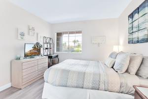 a white bedroom with a bed and a dresser at Esprit Vacation Condo in Palm Springs +20 photos