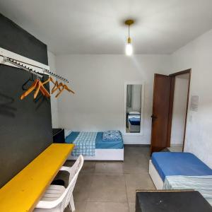 a room with two beds and a desk in it at Hostel Brooklin in São Paulo