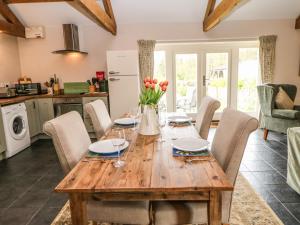 a kitchen and dining room with a wooden table and chairs at Shepherds Burn Cottage in Greenhaugh