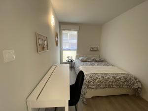um pequeno quarto com uma cama e uma secretária em Appartement familial tout confort - 3 chambres, grande terrasse privative - Vert Buisson - Bruz em Bruz