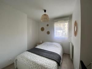 een kleine slaapkamer met een bed en een raam bij Appartement familial tout confort - 3 chambres, grande terrasse privative - Vert Buisson - Bruz in Bruz