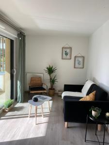 Appartement familial tout confort - 3 chambres, grande terrasse privative - Vert Buisson - Bruz في بروز: غرفة معيشة مع أريكة سوداء وطاولة