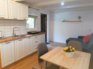 a kitchen and living room with a table and a couch at DOMEK POD SOSNAMI in Krasnobród
