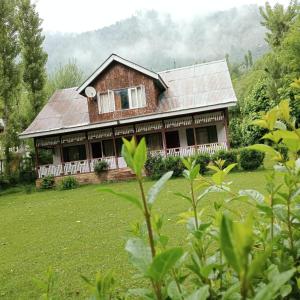 uma casa com um jardim verde em frente em PK cottage em Pahalgam