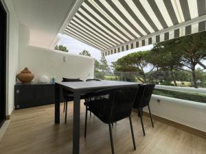 a dining room with a table and chairs and a window at Victory Village 10C in Quinta do Lago