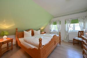 a bedroom with a large wooden bed with white sheets at Landhaus Vilmnitz - Wohnung 1 in Vilmnitz