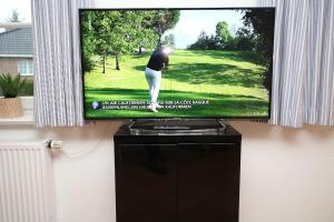 a television screen with a picture of a golfer at Badestra_e 18 a_ Whg_ 1 in Wyk auf Föhr