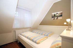 Kleines Zimmer mit einem Bett und einem Fenster in der Unterkunft Am Grünstreifen 31, Whg. 6 "Strandgut" in Wyk auf Föhr