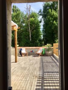a view of a patio with two chairs and a table at Les pieds dans l'eau- gîte l'Estancot-plage privée in Blacons +23 photos