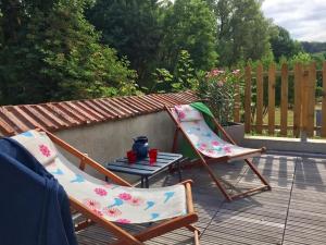 two chairs and a table on a patio at Les pieds dans l'eau- gîte l'Estancot-plage privée in Blacons