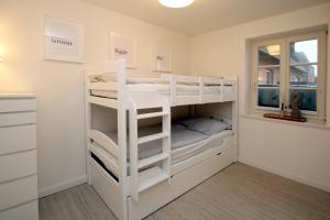 a room with two bunk beds and a window at Doerpstraat 9_ Whg_ 4 in Wyk auf Föhr +7 photos
