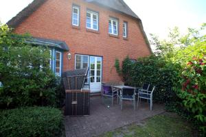 a patio with chairs and a table in front of a brick house at Doerpstraat 9_ Whg_ 4 in Wyk auf Föhr