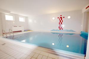 a large swimming pool in a white tile room with at Doerpstraat 9_ Whg_ 4 in Wyk auf Föhr