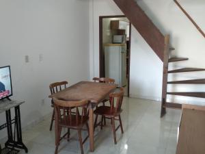 a dining room with a table and chairs and a staircase at CASA AMARELA in Salvador