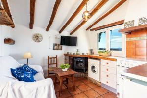 阿爾考辛的住宿－Ático El Pasero con Solarium y Barbacoa，厨房以及带沙发和桌子的客厅。