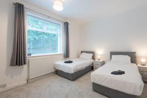 2 Betten in einem Zimmer mit Fenster in der Unterkunft Hilltown Apartment in Dundee
