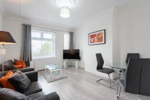 a living room with a couch and a table at Hilltown Apartment in Dundee
