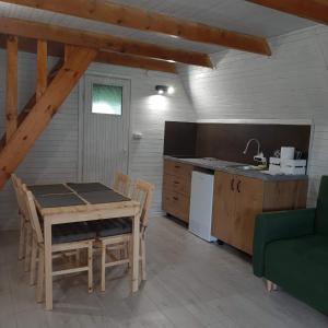 uma cozinha com uma mesa de madeira, uma mesa e cadeiras em domek good vibes B em Gnieżdżewo